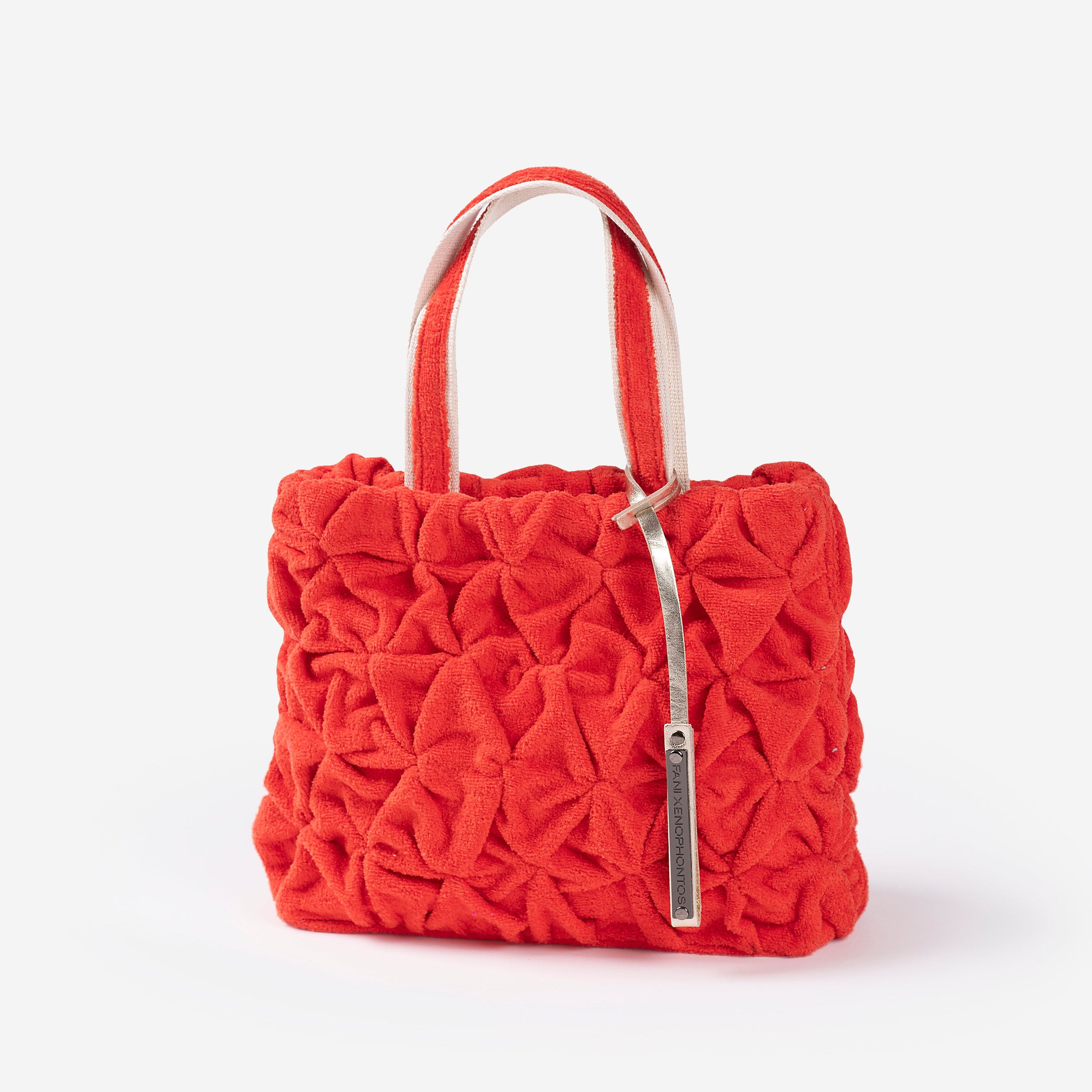 Red textured handbag with a silver handle on a white background