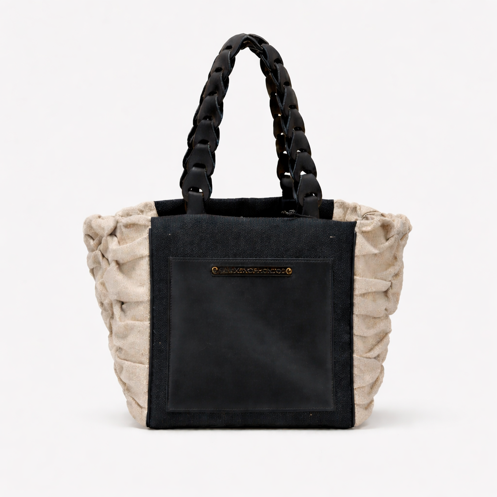 Handbag with braided handle and black front pocket on a white background