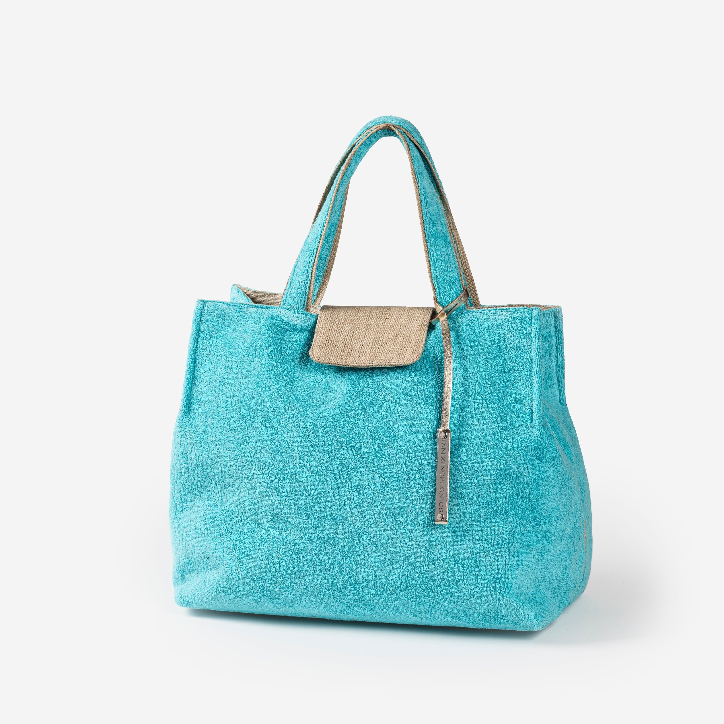 Turquoise beach bag with a beige patch on a white background