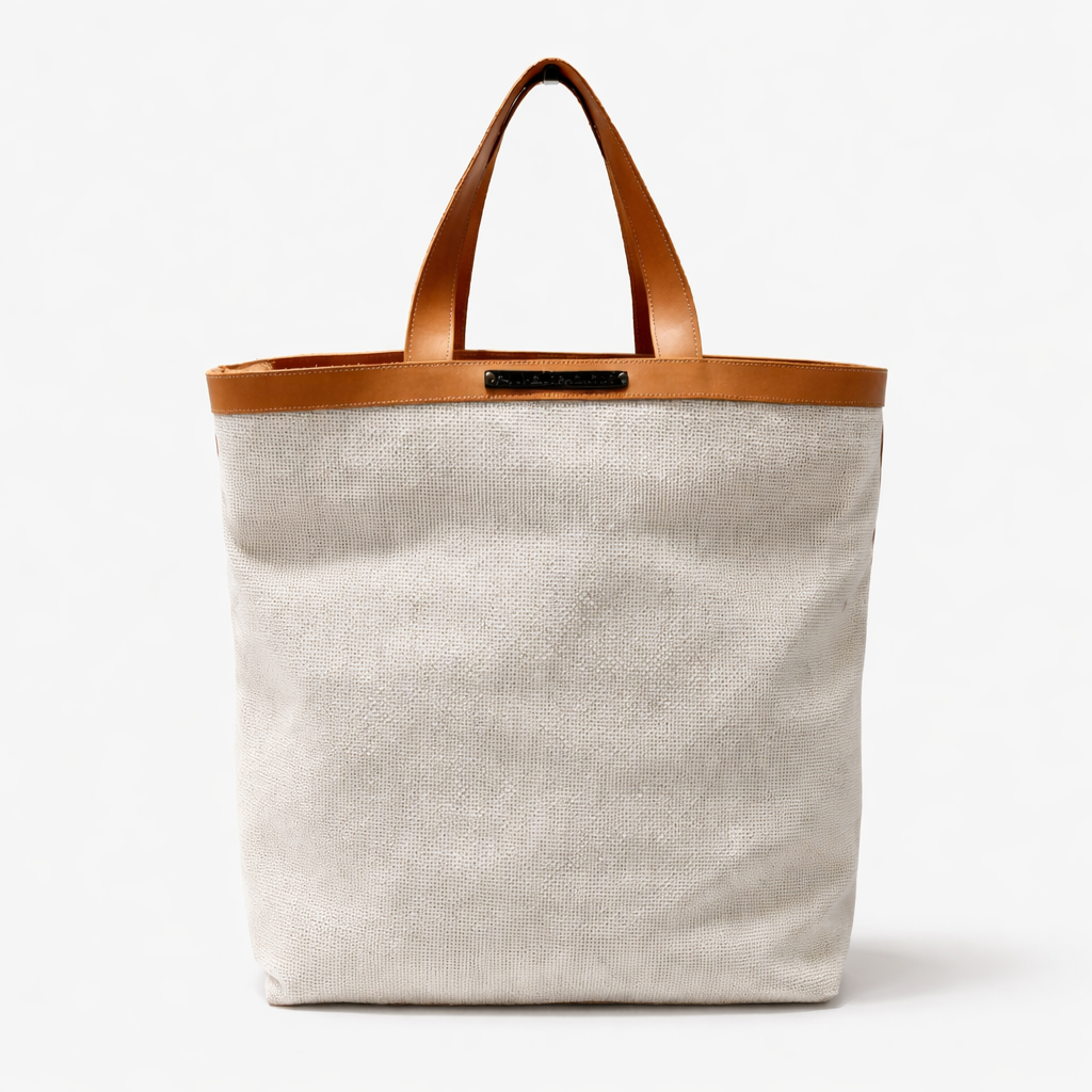 Beach bag with brown leather handle and trim on a white background